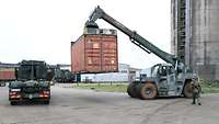 Ein Container wird auf einen LKW verladen.