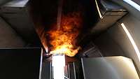 Flammen stehen an der Decke der Flugzeugkabine. 