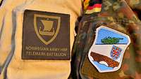 Schulter an Schulter Ärmel zweier Soldaten mit einem norwegischen und einem deutschen Patch