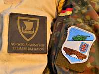 Schulter an Schulter Ärmel zweier Soldaten mit einem norwegischen und einem deutschen Patch