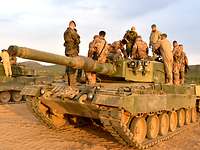 Auf einem norwegischen Panzer stehen mehrere deutsche und norwegische Soldaten.