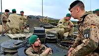 Ein norwegischer und deutscher Soldat auf einem Panzer im Gespräch