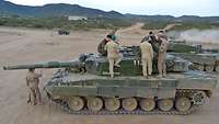 Auf einem norwegischen Panzer stehen mehrere deutsche und norwegische Soldaten.