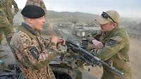Auf einem norwegischen Panzer stehen mehrere deutsche und norwegische Soldaten.