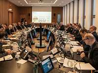 Viele meschen an eienm ovalen Tisch 