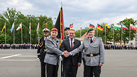 Der Minister und zwei Soldaten schütteln sich die Hände 