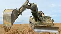 Ein Panzer bei Erdarbeiten mit Baggerschaufel und Schiebeschild
