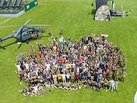 Sportfest Luftbild mit vielen Menschen, dahinter ein Helikopter.