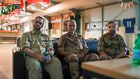 Drei Militärseelsorger sitzen im Camp im Auslandseinsatz auf einem Sofa und unterhalten sich.