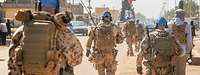 Mehrere Soldaten mit blauen Basecaps laufen auf einer Straße in Gao.