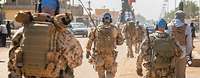 Mehrere Soldaten mit blauen Basecaps laufen auf einer Straße in Gao.