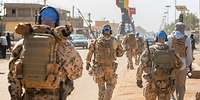 Patrouille in Gao während der UN-Mission MINUSMA Mehrere Soldaten mit blauen Basecaps laufen auf einer Straße in Gao.
