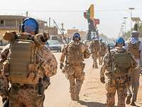 Mehrere Soldaten mit blauen Basecaps laufen auf einer Straße in Gao.