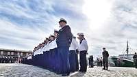 Soldatinnen und Soldaten in Marineuniform vor einem Schiff