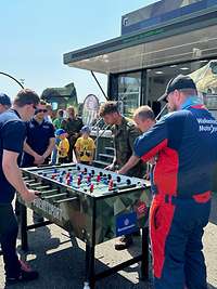 Vor dem Karrieretruck spielen Besucherinnen und Besucher am Kickertisch mit Bundeswehr-Angehörigen.