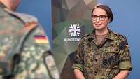 Ein Soldat spricht in einem Studio mit einer Soldatin.