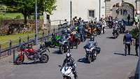 Die Biker mit ihren Motorrädern an der Abteikirche