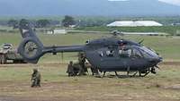 Soldatinnen und Soldaten sichern einen Helikopter und verladen einen verwundeten Kameraden.