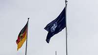 The German and NATO flags are flying in the wind.