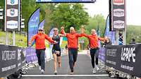 Zwei Sportlerinnen und zwei Sportler beim Zieleinlauf. Sie gehören zum Elite Team Mixed Relay.