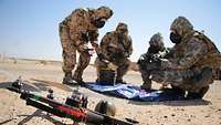 Soldaten in Schutzausrüstung inspizieren eine Drohne