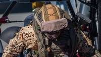 Ein Soldat in Tropenuniform befindet sich an Bord eines Schiffes.