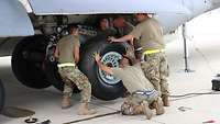 Technicians changing an aircraft tyre.