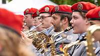 Soldatinnen und Soldaten in der Nahaufnahme beim Spielen ihrer Instrumente