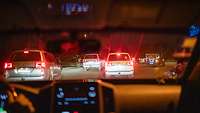 Fahrzeuge bewegen sich bei Nacht im dichten Verkehr.