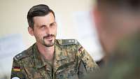 Ein Soldat sitzt an einem Tisch.