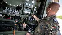 Ein Soldat prüft an einem Tankwagen die Filteranlage, die den Kraftstoff reinigt.
