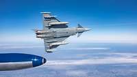 A jet aircraft in lateral flight at a high altitude.
