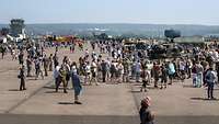 Besucher und Geräte auf einem Flugfeld am Tag der Bundeswehr