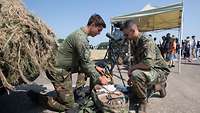 Ein deutscher und ein niederländischer Soldat prüfen einen Sanitätsrucksack am Tag der Bundeswehr