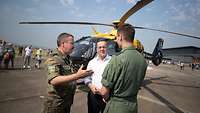 Minister Pistorius spricht mit zwei Soldaten vor einem Hubschrauber