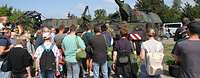 Ein Soldat spricht vor einer Panzerhaubitze 2000 zu Besuchern am Tag der Bundeswehr