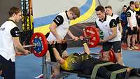 Ein Sportler beim Bankdrücken mit der Langhantel