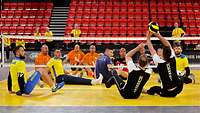 Mehrere Sportler spielen Sitzvolleyball