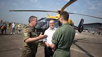 Drei Männer vor einem Hubschrauber