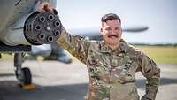 Ein Soldat lehnt an die Kanone des Kampfjets A-10