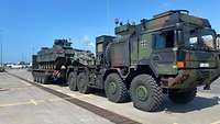 Auf einem Schwerlasttransporter steht ein Schützenpanzer.