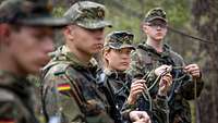 eine Soldatin und drei Soldaten halten Seile in der Hand