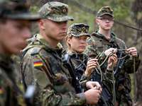 eine Soldatin und drei Soldaten halten Seile in der Hand