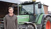 Ein Mann steht vor einem Traktor