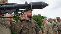 Im Vordergrund hält ein litauischer Soldat eine Panzerfaust. Daneben steht ein deutscher Soldat.