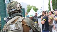 Szene einer Demonstration. Im Vordergrund ein Soldat der Feldjägertruppe