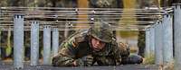 Ein Soldat durchkriecht ein Hindernis