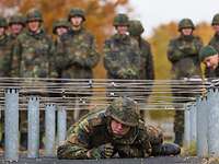 Ein Soldat durchkriecht ein Hindernis