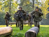 Soldaten mit Gepäck gehen über eine Hindernisbahn