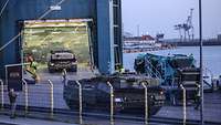 Ein Panzer fährt durch das geöffnete Tor auf eine Fähre.